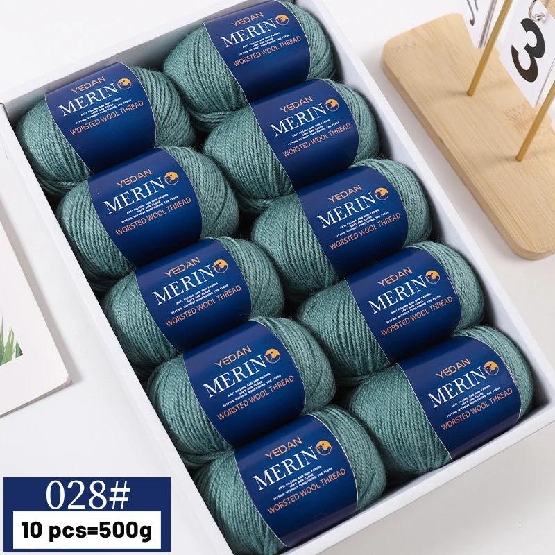 A box of 10 skeins of YEDAN MERINO worsted wool thread yarn in various shades of green and blue.
