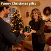 A woman is giving a black nested screw gift box to a man in a living room setting.