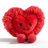 A bright red, fluffy heart-shaped plush cushion with a smiling face.
