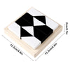 A geometric block puzzle featuring black and white pieces arranged in a square tray.