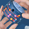 A hand holds a blue 3D rotating slide puzzle cube filled with colorful plastic balls.