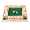 A wooden game board for a four-player dice game with numbered wooden dice and a green playing area.