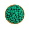 A wooden bowl filled with numerous small, round, green silicone beads for jewelry making