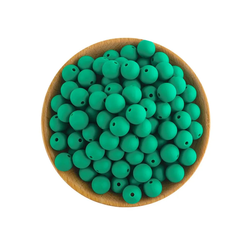 A wooden bowl filled with numerous small, round, green silicone beads for jewelry making
