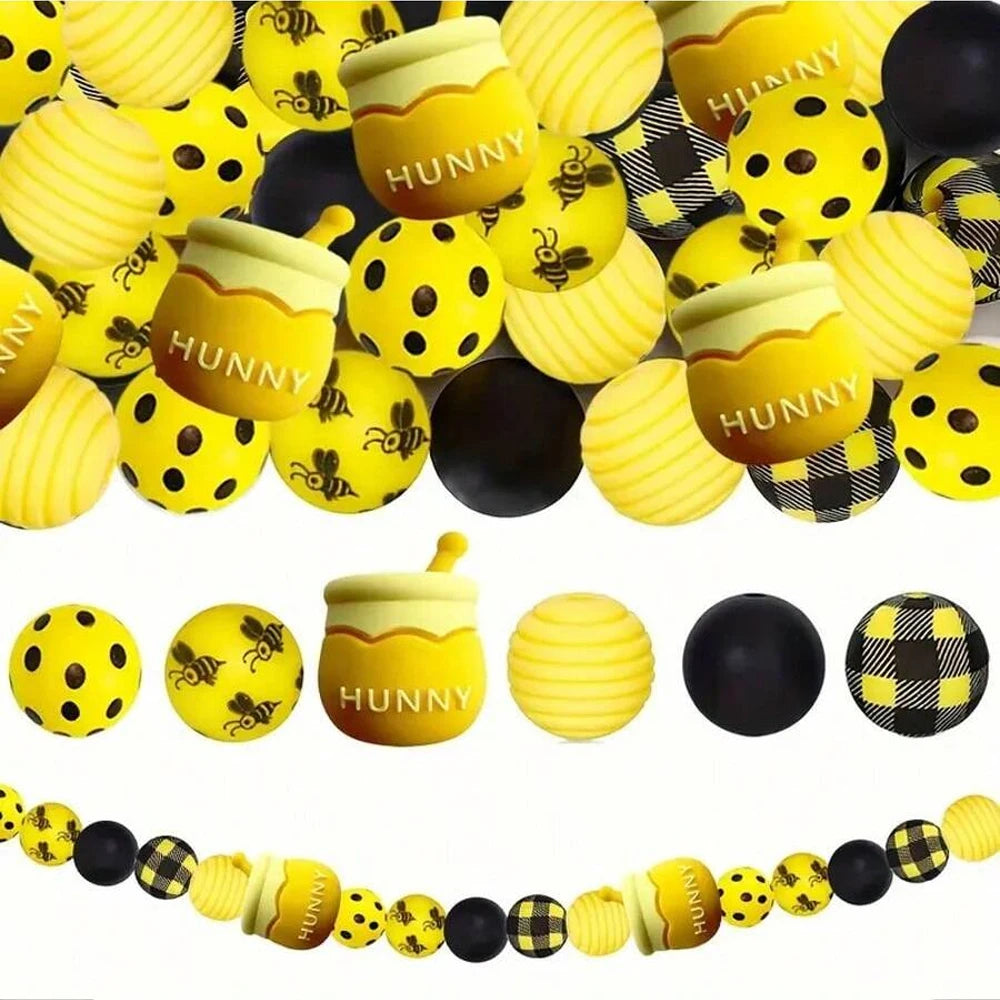A collection of yellow and black silicone beads shaped like bees for DIY crafts.