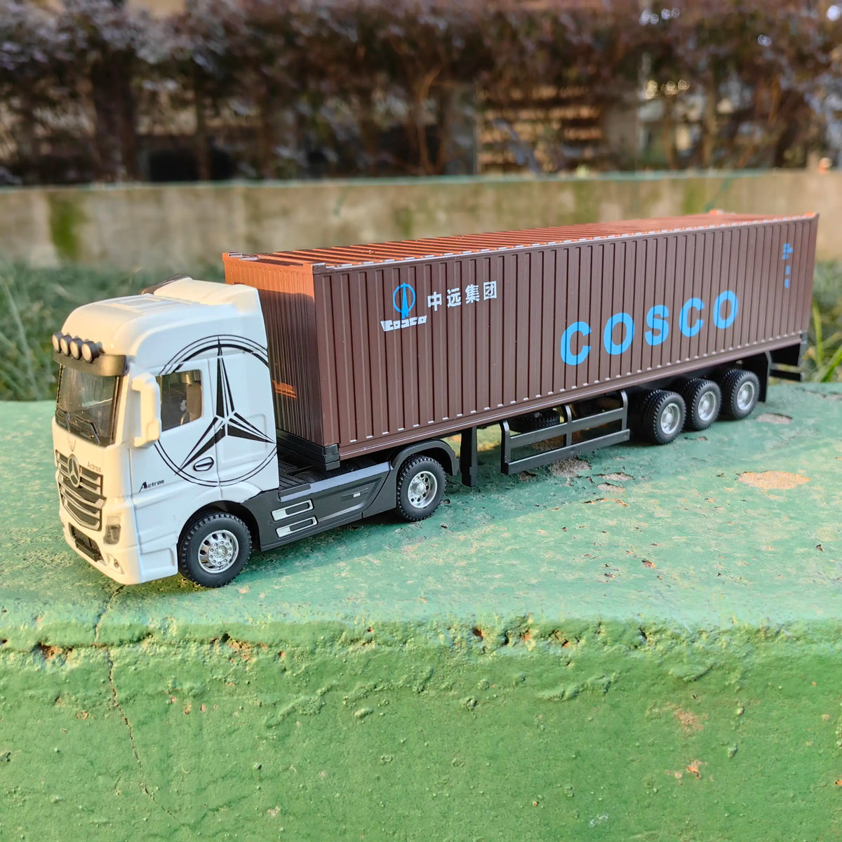 A 1:50 scale diecast model of a white truck pulling a brown COSCO container truck.