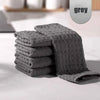A stack of grey ultra-absorbent microfiber kitchen cleaning cloths on a white surface.