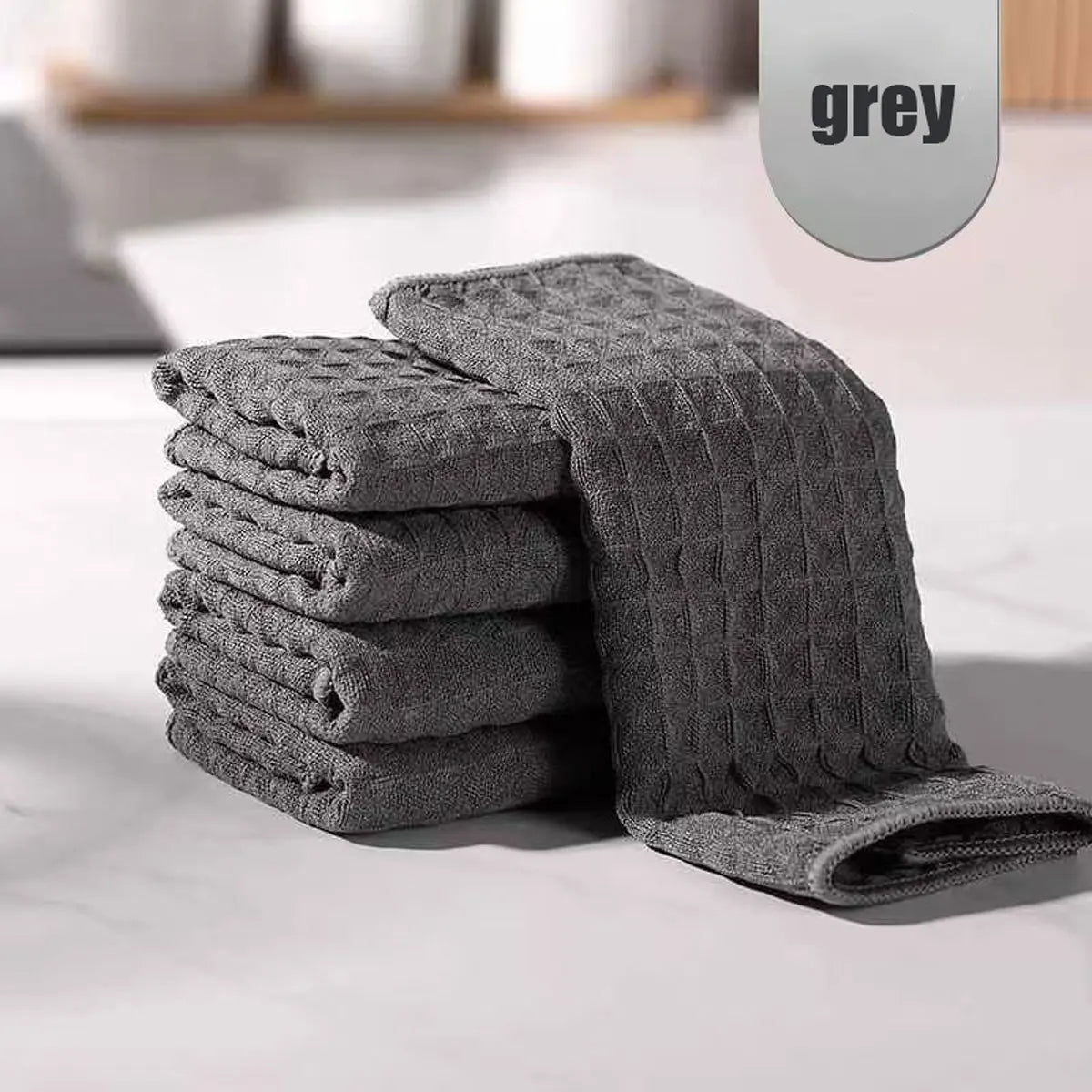 A stack of grey ultra-absorbent microfiber kitchen cleaning cloths on a white surface.