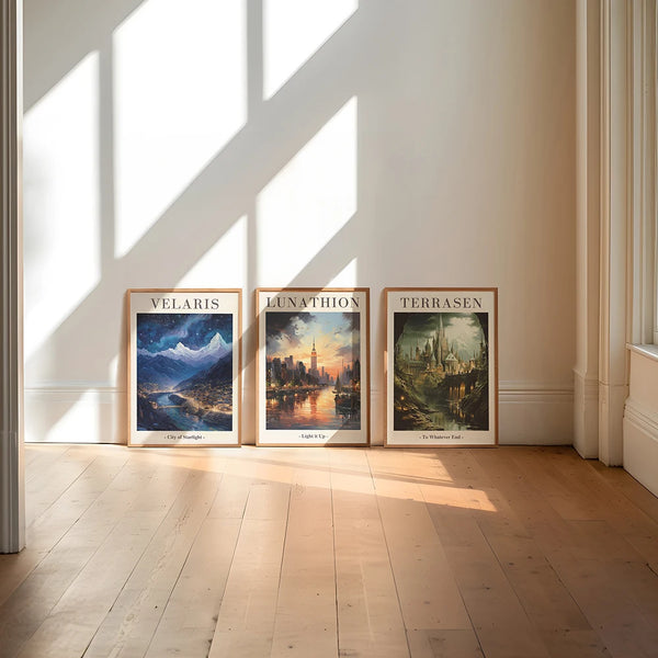 Three framed landscape prints titled Velaris Lunathion and Terrasen displayed on a light-colored wall.