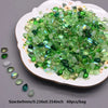 A pile of green and clear water drop Czech glass beads for jewelry making