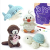 A set of seven crocheted amigurumi animals including a blue whale, a white duck, and a brown bear.