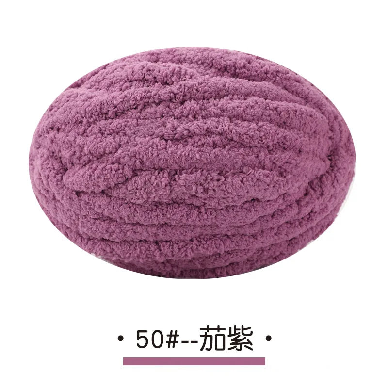 A ball of purple chunky chenille yarn used for hand knitting projects.
