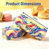 A yellow and purple squishy butter stress relief toy next to a croissant.