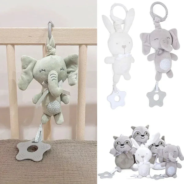 A collection of soft gray and white plush animal rattles, including an elephant and a bunny, displayed on a wooden surface.