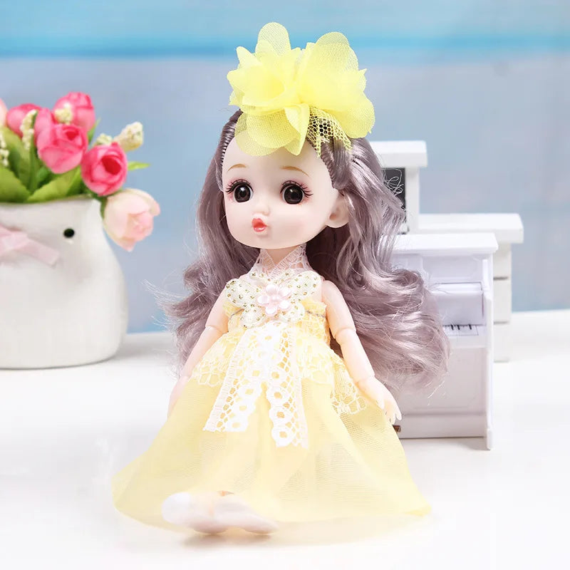 A 17cm articulated princess doll with long gray hair and a yellow dress, sitting next to a white box.