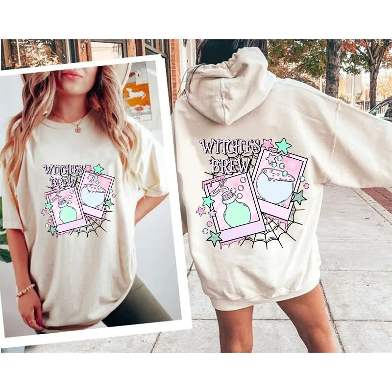 A light beige hoodie featuring embroidered witch brew iron-on patches on the chest.