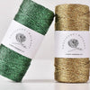 Two spools of metallic gold and green macrame yarn for knitting and crochet