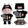A set of black and white knitted clothing for a doll figure including a hat, gloves, and shorts.