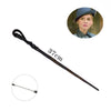 A long, dark metal magic wand with a curved handle and a pointed tip, shown next to a woman wearing a hat.