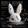 A white plush bunny toy with blue accents and a bandage design displayed on a dark background.
