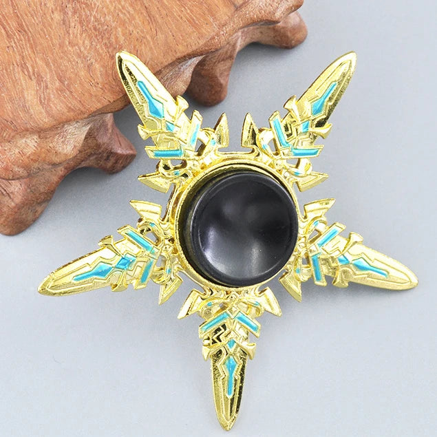 A gold metal fidget spinner with a rainbow finish is shown resting on a wooden surface.