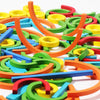 Colorful wooden creative sticks and rings puzzle pieces scattered on a white surface.