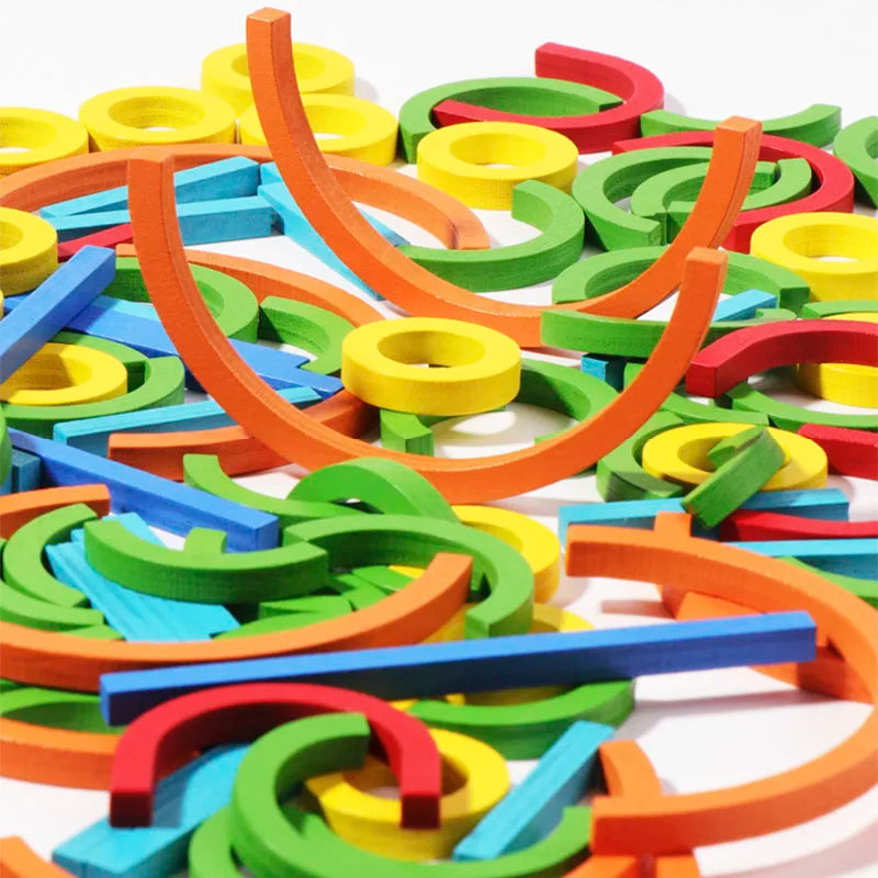 Colorful wooden creative sticks and rings puzzle pieces scattered on a white surface.