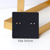 A black square jewelry display card with two oval cutouts is shown next to a gold rectangular card holder.