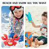 A young child is playing with a red crab claw toy and a blue dinosaur digging tool on a sandy beach.