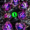 A collection of iridescent resin dice with spinning dragon eye cores scattered on a dark, textured surface.