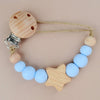 A wooden pacifier clip featuring silicone beads in light blue and natural wood tones.