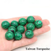 A hand holds several green striped crystal spheres, identified as Taiwan Turquoise.