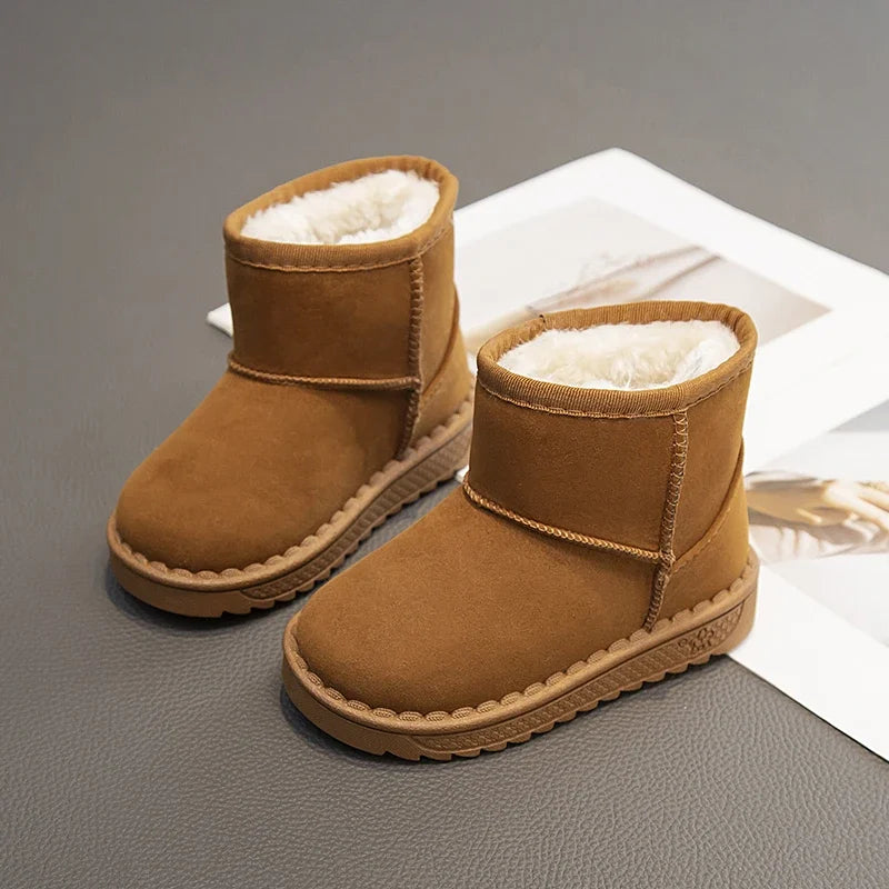 A pair of tan suede winter boots with fluffy white fur lining, shown on a gray surface.