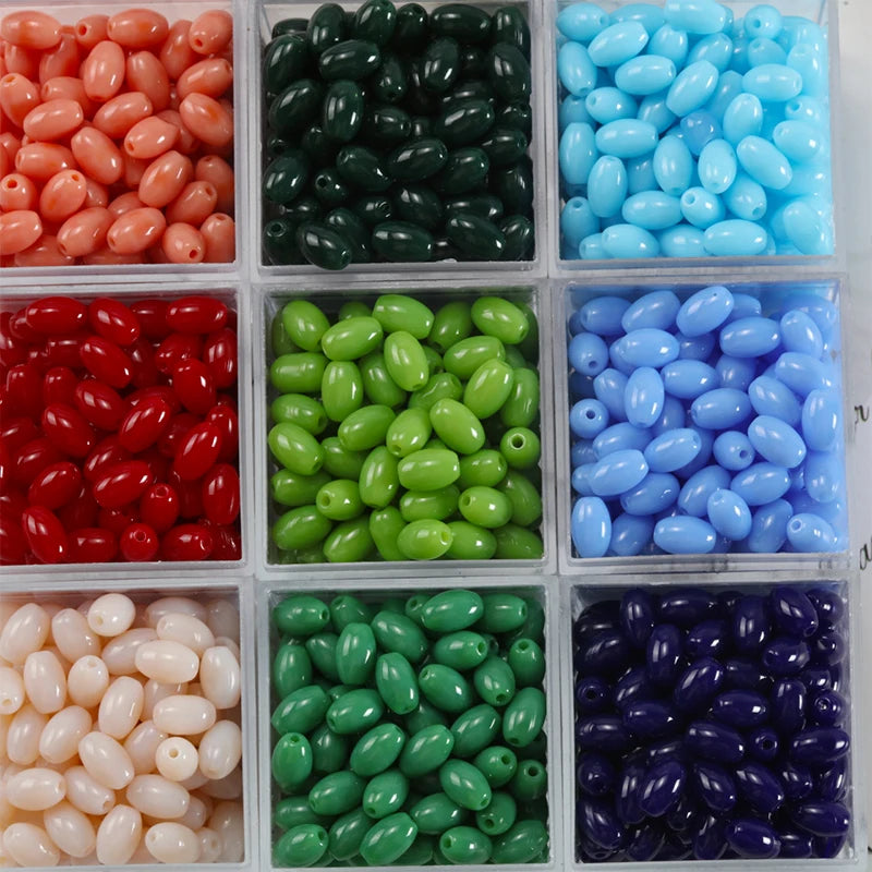 A collection of oval glass rice grain beads in various colors including red, green, blue, and purple.