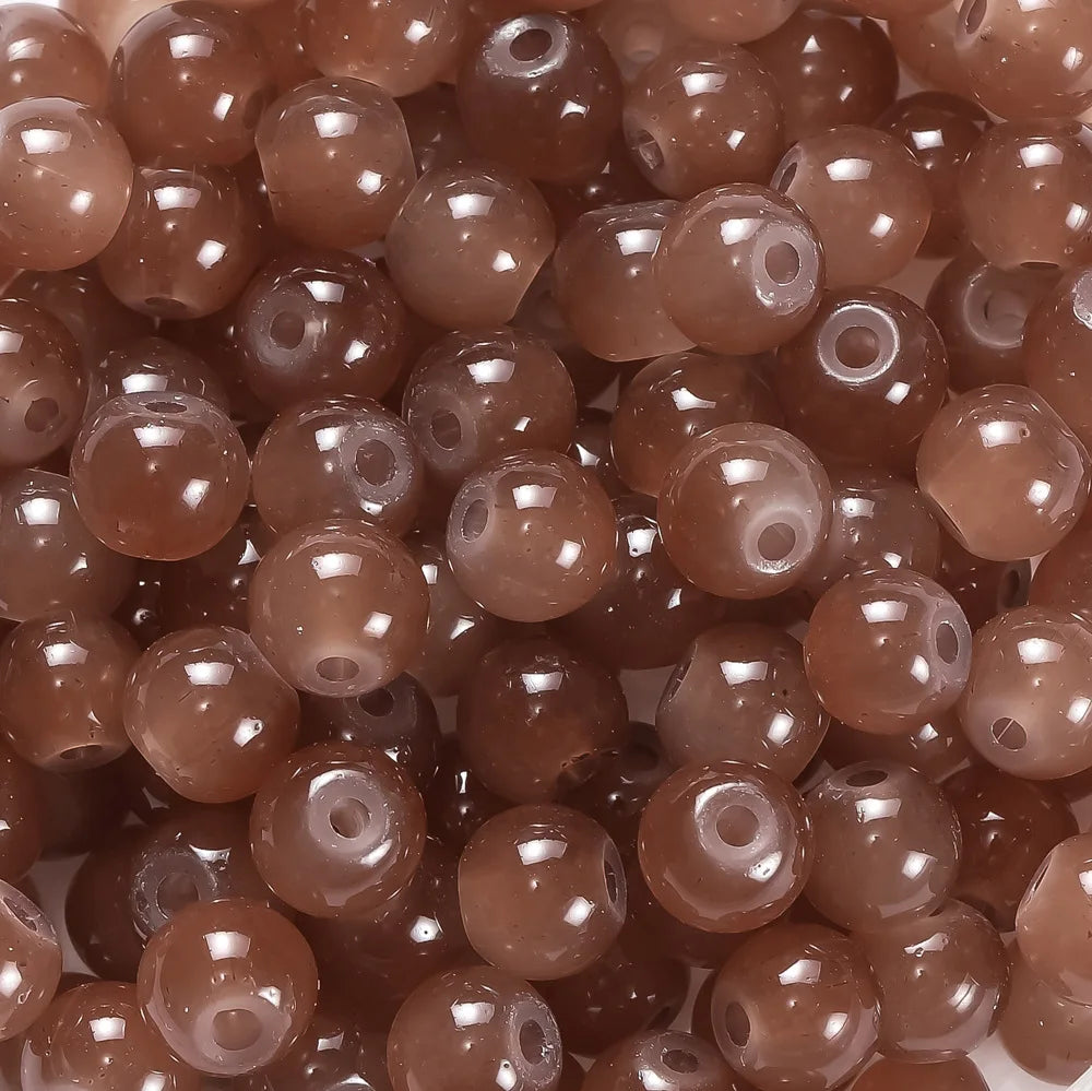 A close-up view of small, round, brown glass beads for DIY jewelry making.