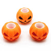 Three small orange pumpkin squishy fidget toys with carved faces and pink interiors