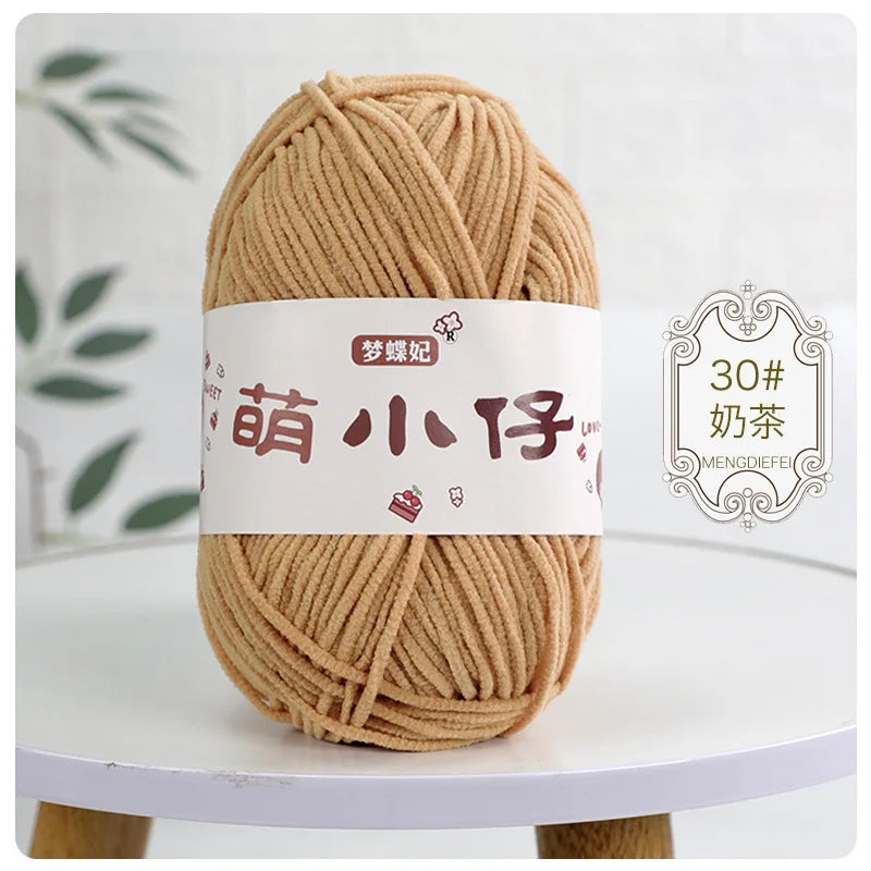 A ball of light brown chenille yarn labeled with Chinese characters for knitting and crochet.