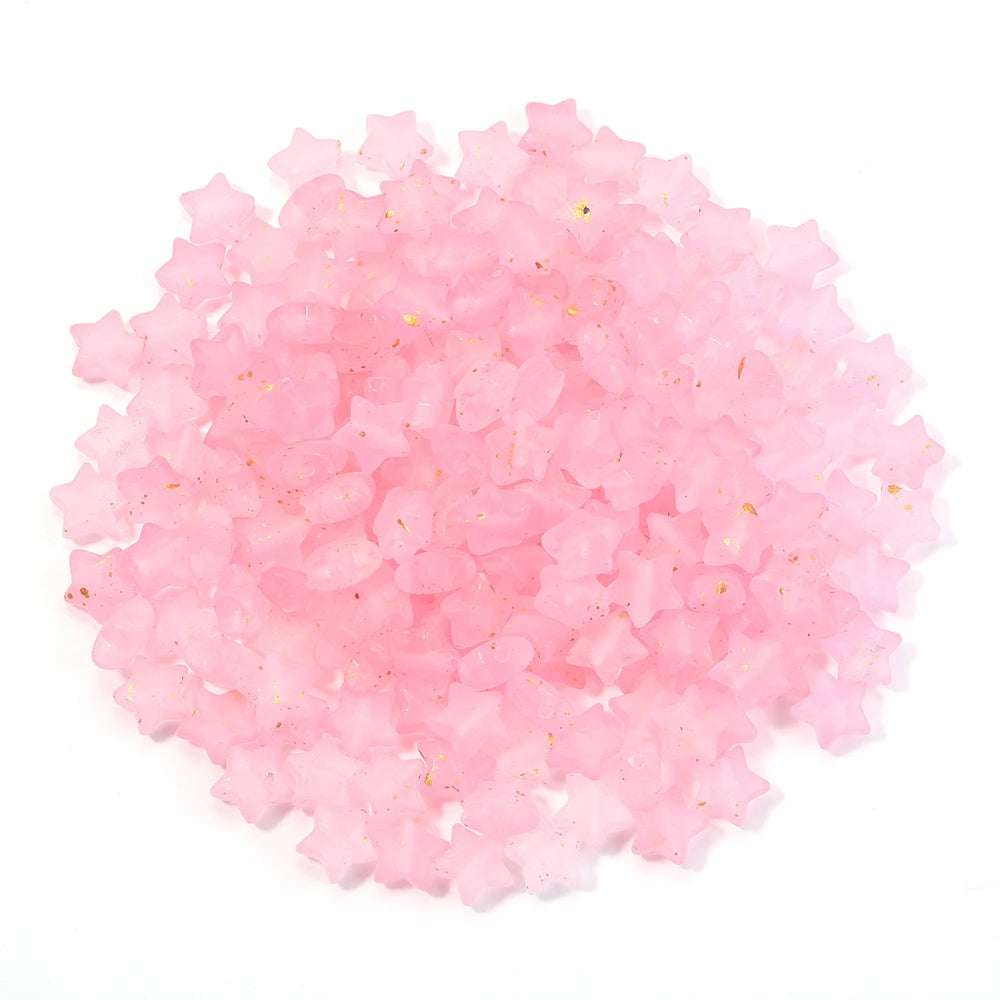 A pile of pink and clear star-shaped acrylic beads for jewelry making