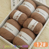 A box filled with twelve balls of brown wool yarn labeled Woolyarn for knitting
