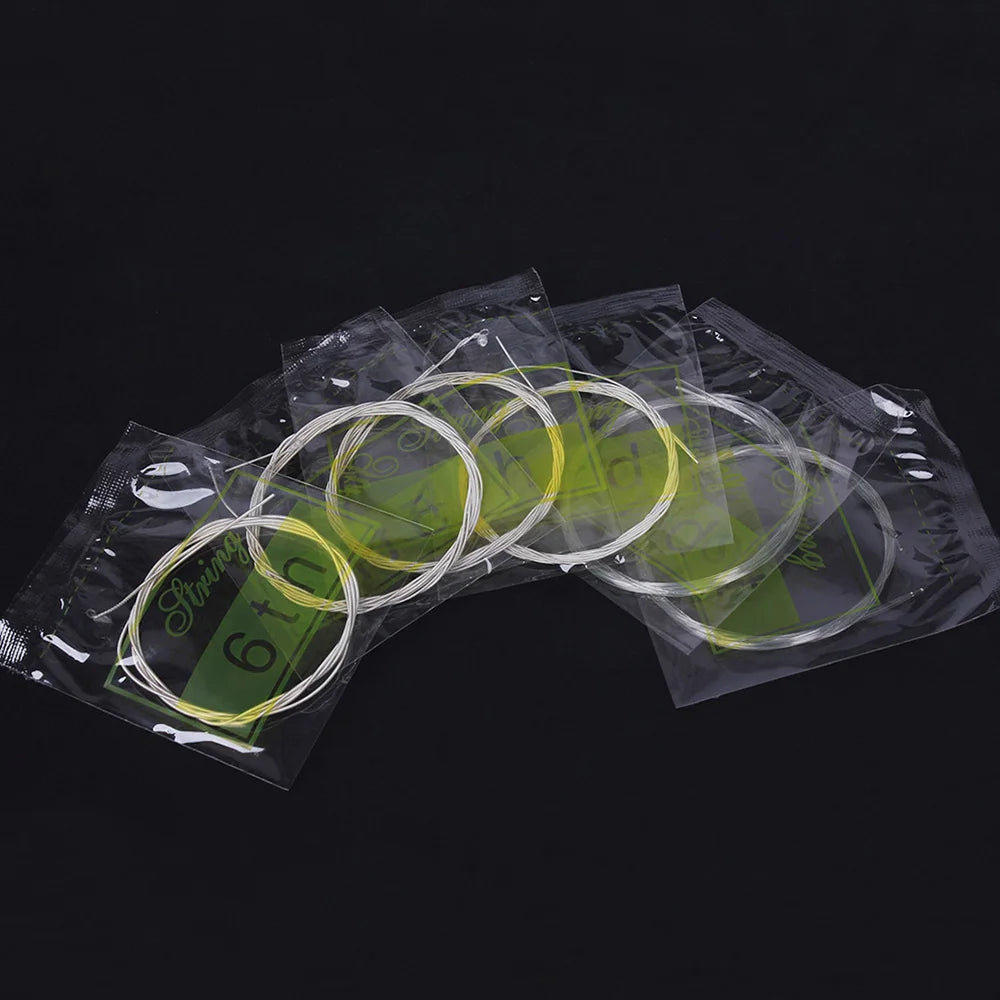A set of six thin, silver-plated copper alloy strings packaged in clear plastic bags.