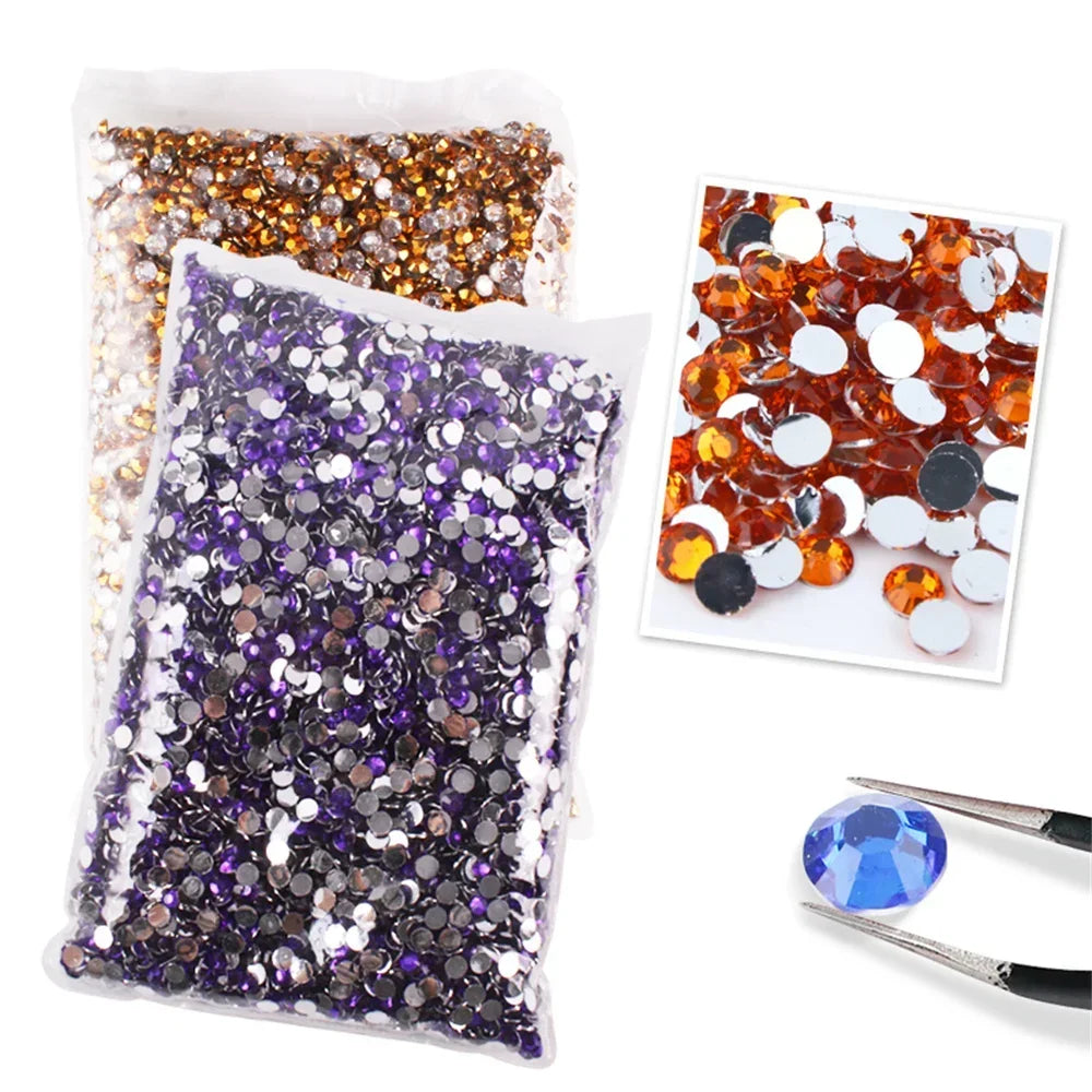 A collection of flat-back resin rhinestones in various colors including gold, purple, and silver, displayed in a clear plasti