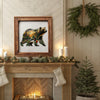 A framed artwork of a bear and other animals hangs above a fireplace mantel decorated with greenery.