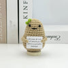 A handwoven crochet ornament shaped like a potato with green sprouts, used as desk decor.