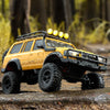 A yellow 1:18 scale remote control off-road climbing car with black tires and auxiliary lights on a rock surface.
