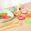 A wooden salad pretend play food set featuring various colored fruits and vegetables like carrots, tomatoes, and cucumbers.