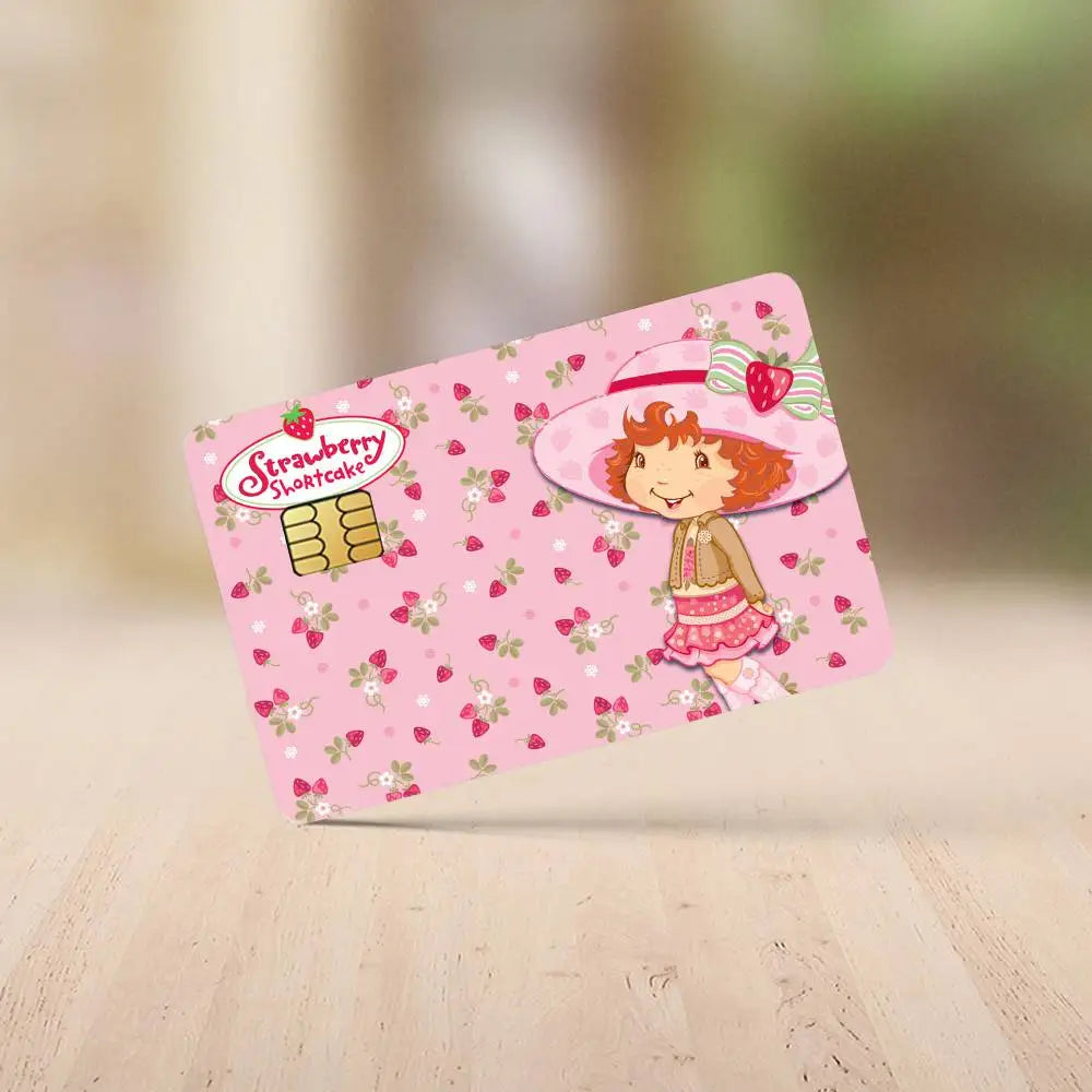 A pink credit card sticker featuring a Strawberry Shortcake cartoon character and fruit patterns.