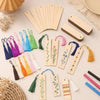 A collection of blank wooden bookmarks with various tassels in shades of green, pink, purple, and yellow arranged on a light 