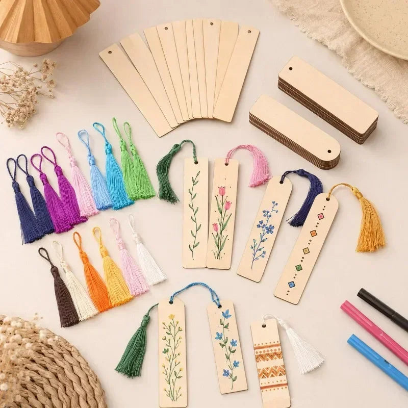 A collection of blank wooden bookmarks with various tassels in shades of green, pink, purple, and yellow arranged on a light 