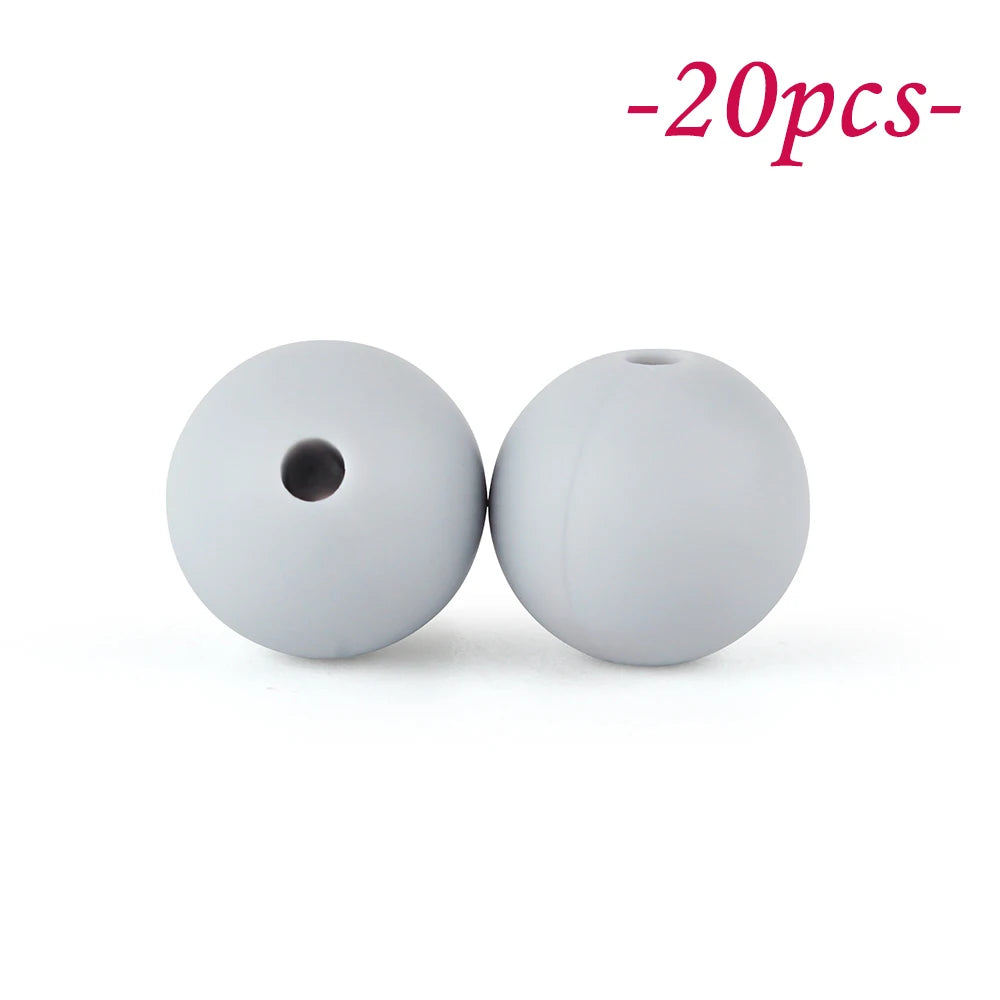 Two round, white silicone beads with a hole are shown against a white background.