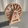 A wooden gemstone building block featuring a circular wheel with cutouts and an acrylic crystal centerpiece.
